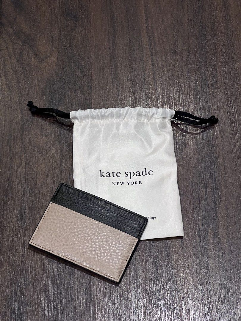 Kate Spade Madison Slim Card Holder (Category: Wallets & Card holders) located in Quezon City. Submitted by cmrls (Listing ID 1422815908, Image 2). Description: - Kate Spade Madison Small Slim Card Holdercard holder - Stylish black and tan color block design - Multiple card slots for organization - Includes Kate Spade dust bag - Features the Kate Spade logo.