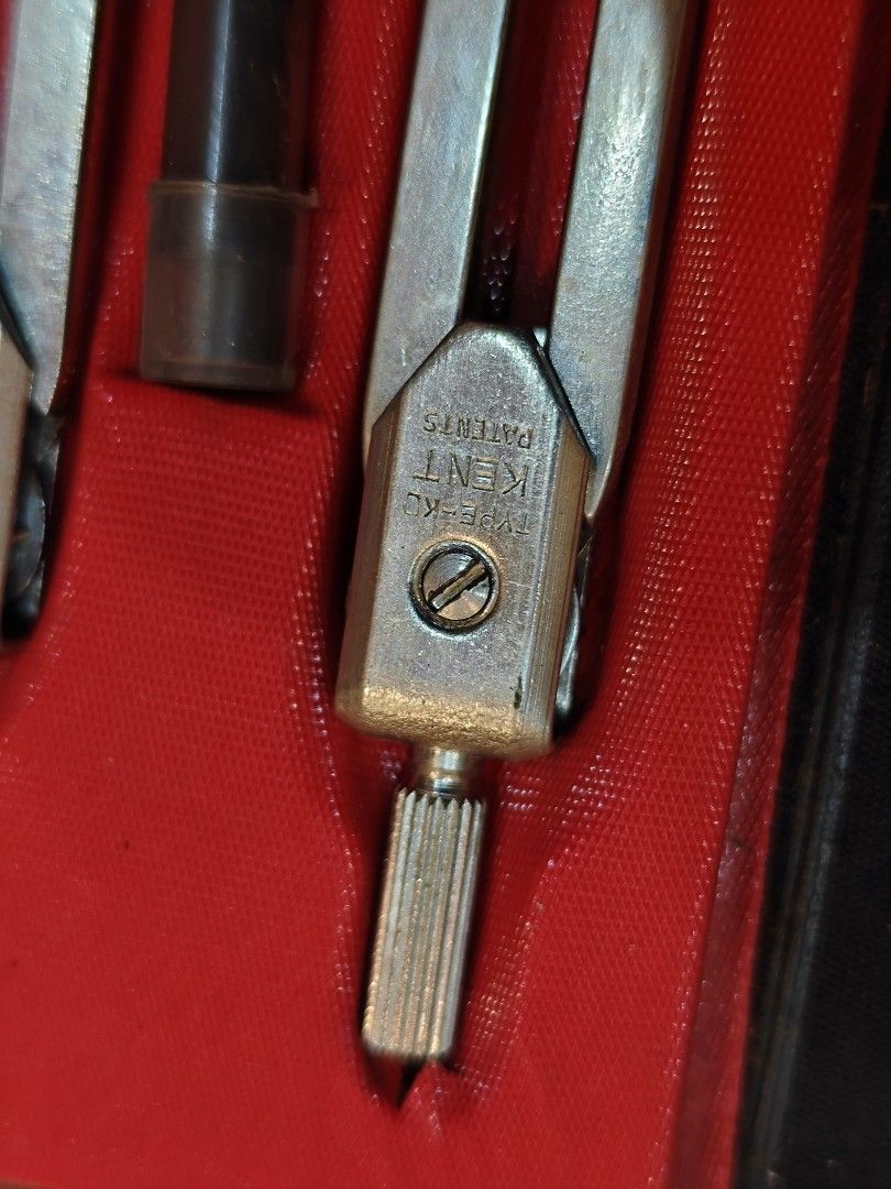 Kent Drawing Compass Set (Category: Stationery & School Supplies) located in San Miguel. Submitted by mharly0221 (Listing ID 1422898033, Image 2). Description: - Kent drawing compass set - Includes two metal compasses - Comes with a small black tube - Housed in a black case with a red interior - Case features a snap closure - Brand: "Kent".