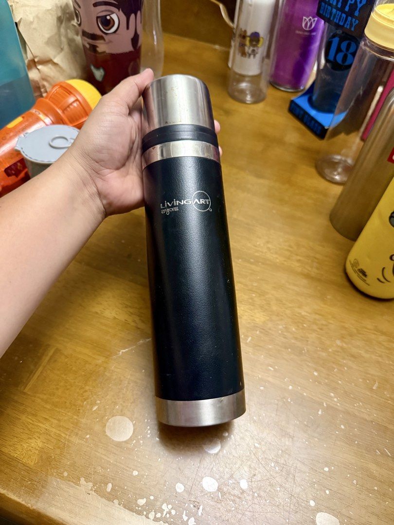 Living Art Thermos (Category: Coffee & Tea Tableware) located in Pilar. Submitted by faveanyshop (Listing ID 1422788116, Image 1). Description: - Living Art thermos - Black body with silver top and bottom - Push-button lid - Clean interior - Korean text on the bottom - Keeps drinks hot or cold.