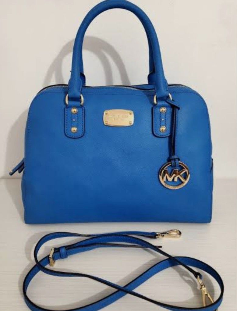 Michael Kors Blue Satchel Handbag (Category: Luxury Bags & Wallets) located in Cavite. Submitted by sossythrift (Listing ID 1422788846, Image 1). Description: - Michael Kors satchel handbag - Vibrant blue color - Top handle and detachable shoulder strap - Gold-tone hardware - MK logo charm - Structured shape - Zip closure - Michael Kors logo plaque.