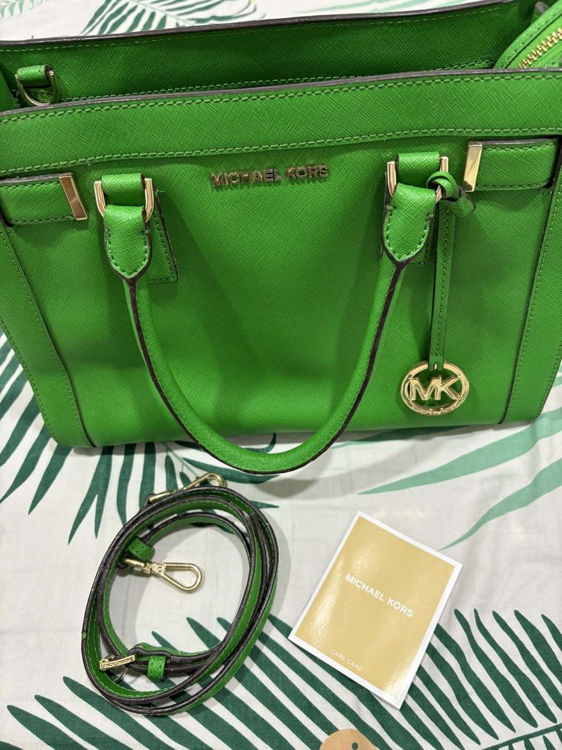 Michael Kors Green Satchel Handbag (Category: Luxury Bags & Wallets) located in Dasmarinas. Submitted by kddeclutterr (Listing ID 1422780214, Image 2). Description: - Authentic Michael Kors satchel handbag - Bright green color - Top handle and detachable shoulder strap - Includes care card - Michael Kors logo lining - Gold-tone hardware - Michael Kors logo charm - Protective metal feet -Price Negotiable .