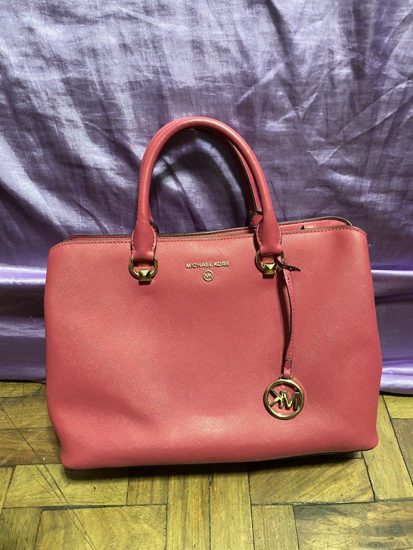 Michael Kors Pink Satchel Handbag (Category: Luxury Bags & Wallets) located in Manila. Submitted by missthrift___ (Listing ID 1422898870, Image 1). Description: - Authentic Michael Kors satchel handbag - Color: Pink - Top handle design - Gold-tone hardware - Detachable MK charm - Interior: Zip pocket - Closure: Zip and magnetic - Protective metal feet at the bottom - issue indicated last pic (9th slide).