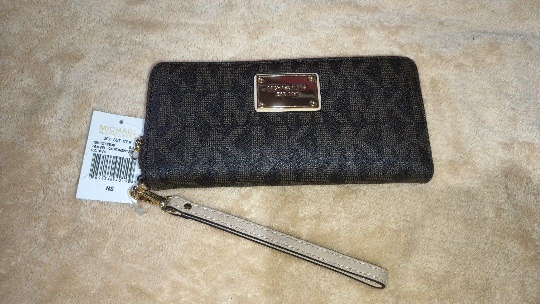 Michael Kors Zip Around Wallet (Category: Wallets & Card holders) located in Tanza. Submitted by declutterolshoppe (Listing ID 1422787599, Image 1). Description: - Michael Kors zip-around wallet - Features MK logo pattern - Includes wrist strap - Multiple card slots and compartments - Comes with original tag - Color: Brown - Hardware: Gold-tone.