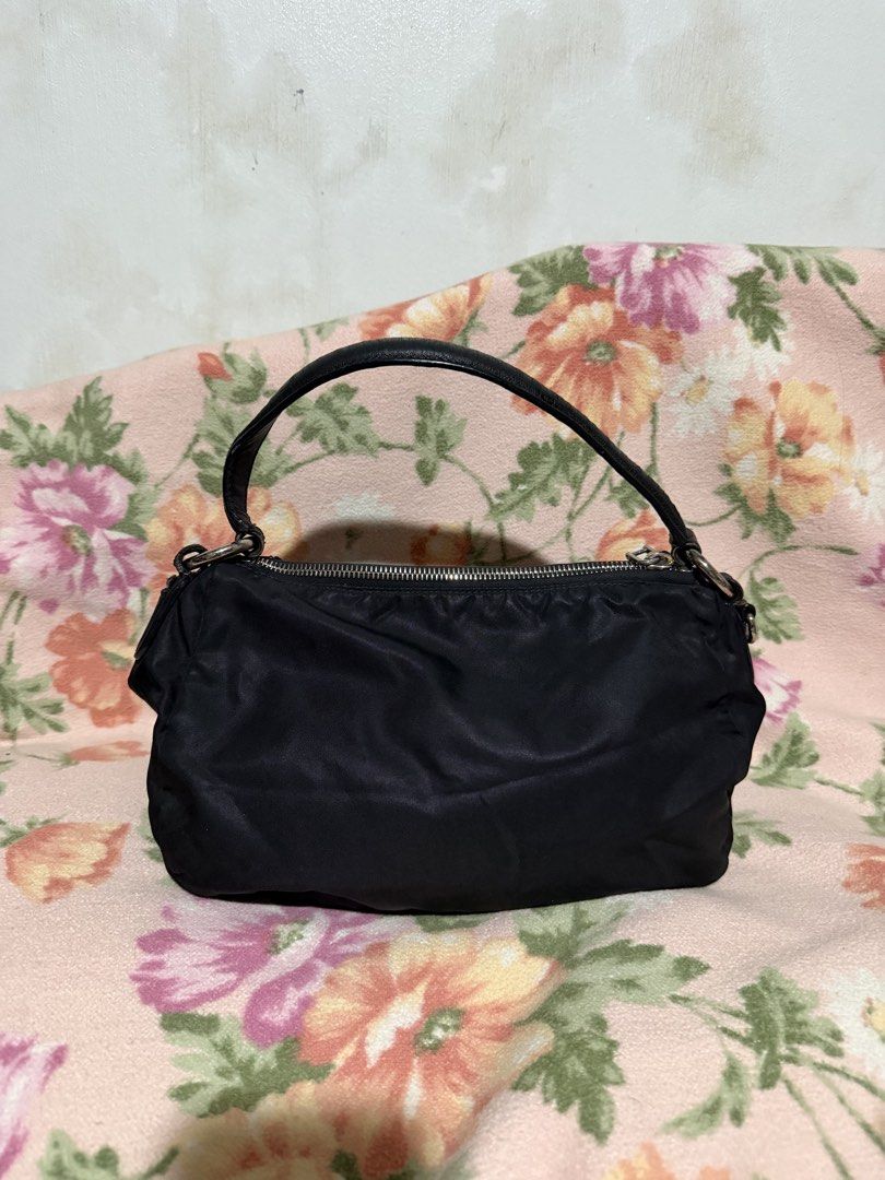 Prada handbag nylon bag (Category: Luxury Bags & Wallets) located in San Pablo. Submitted by prelovedbymistyblue (Listing ID 1422831299, Image 2). Description: Authentic Prada nylon handbag, kili bag. With fading on the hardware. The leather part on the handle has some hardening. With rubber lining issue on the leather part which holds the handle. Riri zipper, with white tag. Missing puller on inner pocket. Selling low for 6500, down to 6000. for
