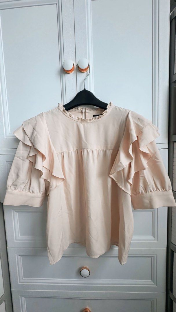 Ruffle Sleeve Blouse (Category: Blouses) located in Pasig City. Submitted by cyebem (Listing ID 1422785410, Image 1). Description: - Light peach blouse - Round neckline with ruffle detail - Short sleeves - Relaxed fit - Dress up or down - Perfect for casual or formal wear.