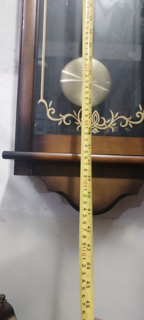 Seiko Quartz Wall Clock (Category: Clocks) located in Caloocan City. Submitted by rowely_jpn (Listing ID 1422748432, Image 2). Description: - Seiko quartz wall clock - Wooden frame - Glass front - Roman numeral clock face - Decorative gold accents - Includes pendulum - Approximately 48 inches tall - In good working condition.