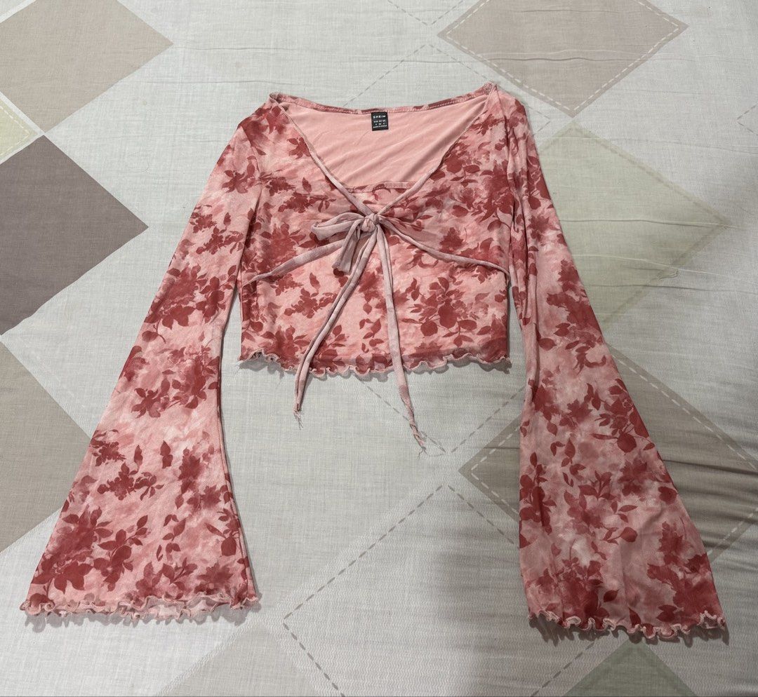 Shein Floral Tie Front Top (Category: Blouses) located in Las Pinas. Submitted by bloomwithjoyph (Listing ID 1422811054, Image 1). Description: Shein top features a floral print and a tie-front design. It has long, flared sleeves and a V-neckline. The top has a light pink inner lining. The size tag indicates it is a size S. Used once.