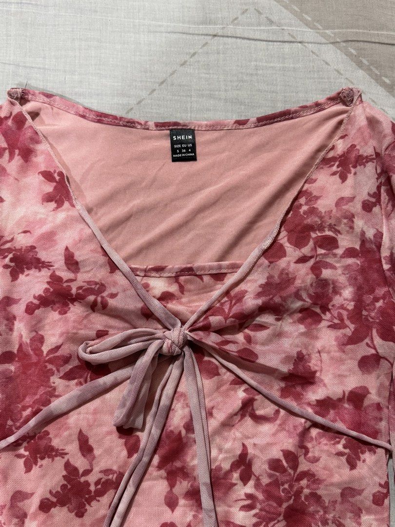 Shein Floral Tie Front Top (Category: Blouses) located in Las Pinas. Submitted by bloomwithjoyph (Listing ID 1422811054, Image 2). Description: Shein top features a floral print and a tie-front design. It has long, flared sleeves and a V-neckline. The top has a light pink inner lining. The size tag indicates it is a size S. Used once.