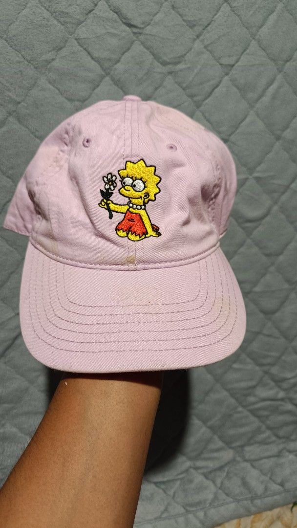The Simpsons Lisa Simpson Cap (Category: Caps & Hats) located in Cagayan de Oro. Submitted by tryzumclothing292513 (Listing ID 1422865337, Image 1). Description: - Light pink cap featuring an embroidered Lisa Simpson design. - Officially licensed by 20th Television. - Manufactured by Mad Engine. - Classic six-panel design. - Curved brim..