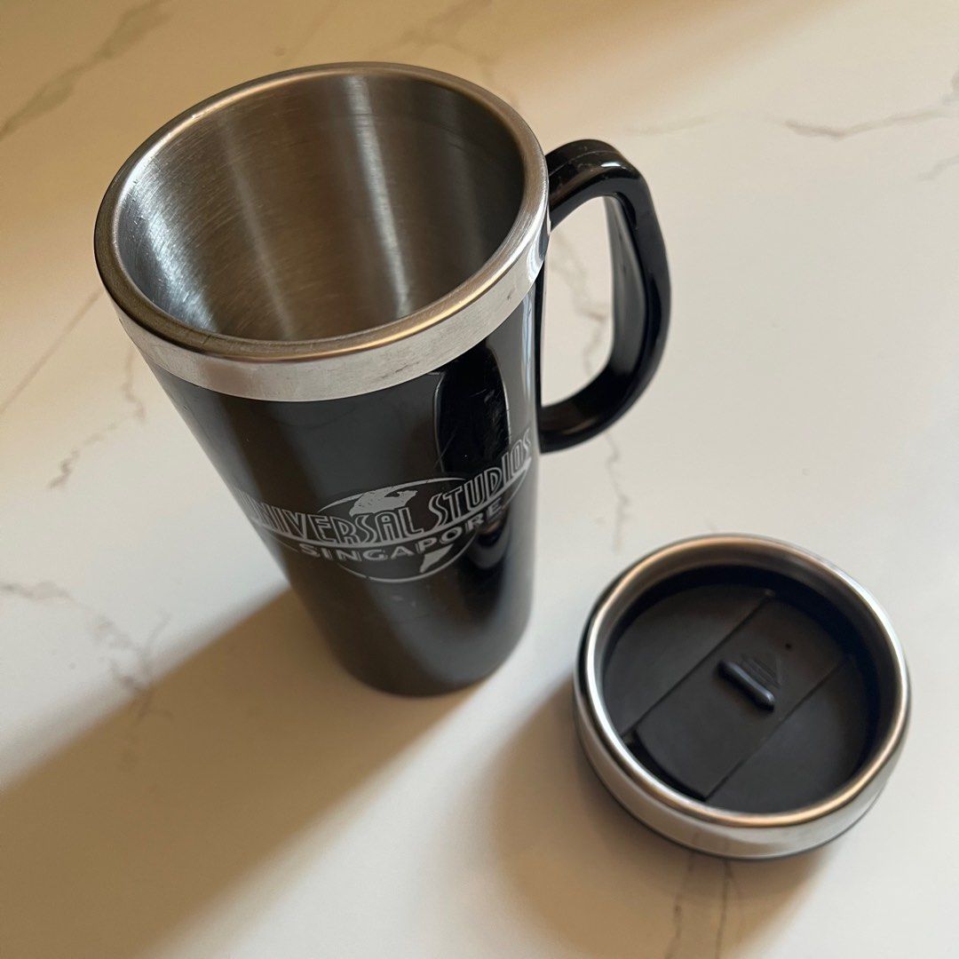 Universal Studios Singapore Travel Mug ORIGINAL (Category: Water Bottles & Tumblers) located in Taguig. Submitted by sdiph (Listing ID 1422782290, Image 3). Description: - Universal Studios Singapore travel mug souvenir, Black color - Features a handle and lid for easy carrying - Made of stainless steel - Universal Studios Singapore logo on front, Original merchandise 100%.