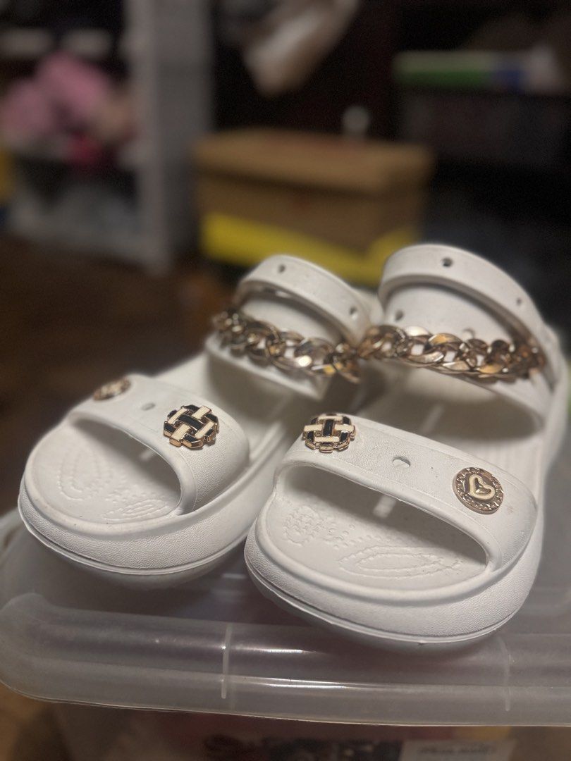 White “Crocs” Sandals with Gold Chain (Category: Flats & Sandals) located in Las Pinas. Submitted by declutterverse (Listing ID 1422871494, Image 1). Description: - White “Crocs” sandals - Gold chain and decorative charms - US size 8 / EU size 39 - Thick sole - Adjustable strap - Perfect for casual wear - Unique design.