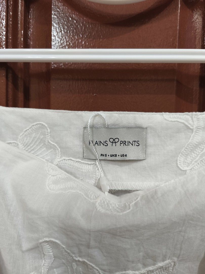 Plains & Prints White Embroidered Square Neck Top (Category: Blouses) located in Legazpi City. Submitted by fhlorms (Listing ID 1422859303, Image 2). Description: White top with square neckline, short sleeves, and embroidered floral design. Lightweight fabric, perfect for warm weather. Versatile style. Could be worn as modern Filipiniana. No to worn please. RfS: Bought then washed and turned a bit small for my fit. Just recently bought (see pic o