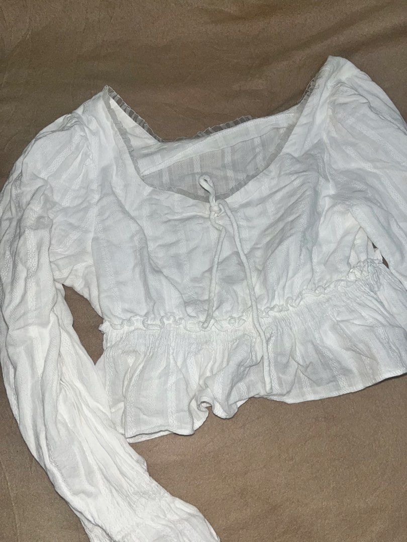 White Long Sleeve Blouse (Category: Blouses) located in Manila. Submitted by quarishop21 (Listing ID 1422827076, Image 2). Description: - MOLORSA white long sleeve blouse - Square neckline with tie detail - Features a ruffled hem - Long sleeves - Textured, striped fabric - Size tag is visible.
