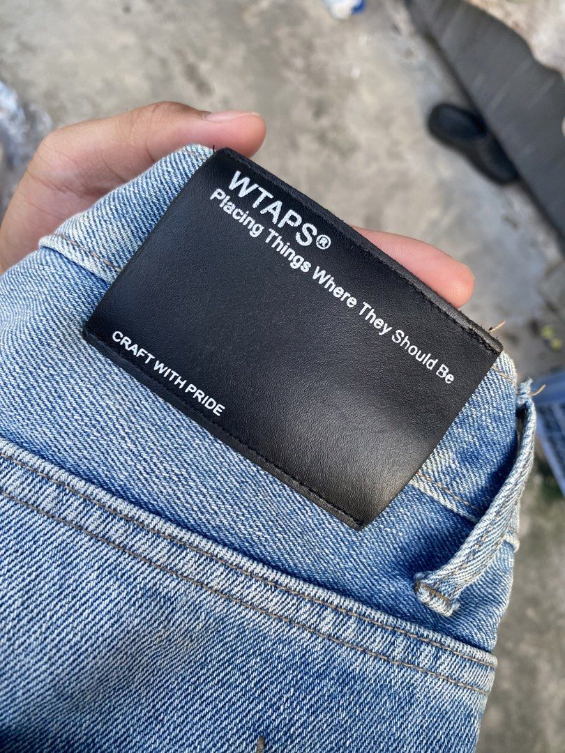 WTAPS Distressed Jeans (Category: Jeans) located in Quezon City. Submitted by yricbugayo66048 (Listing ID 1422809650, Image 3). Description: - Light blue WTAPS jeans - Distressed design - Red tag detail - Leather WTAPS logo patch - Classic five-pocket design - Straight leg fit - Faded wash on back - Size tag visible in photos.
