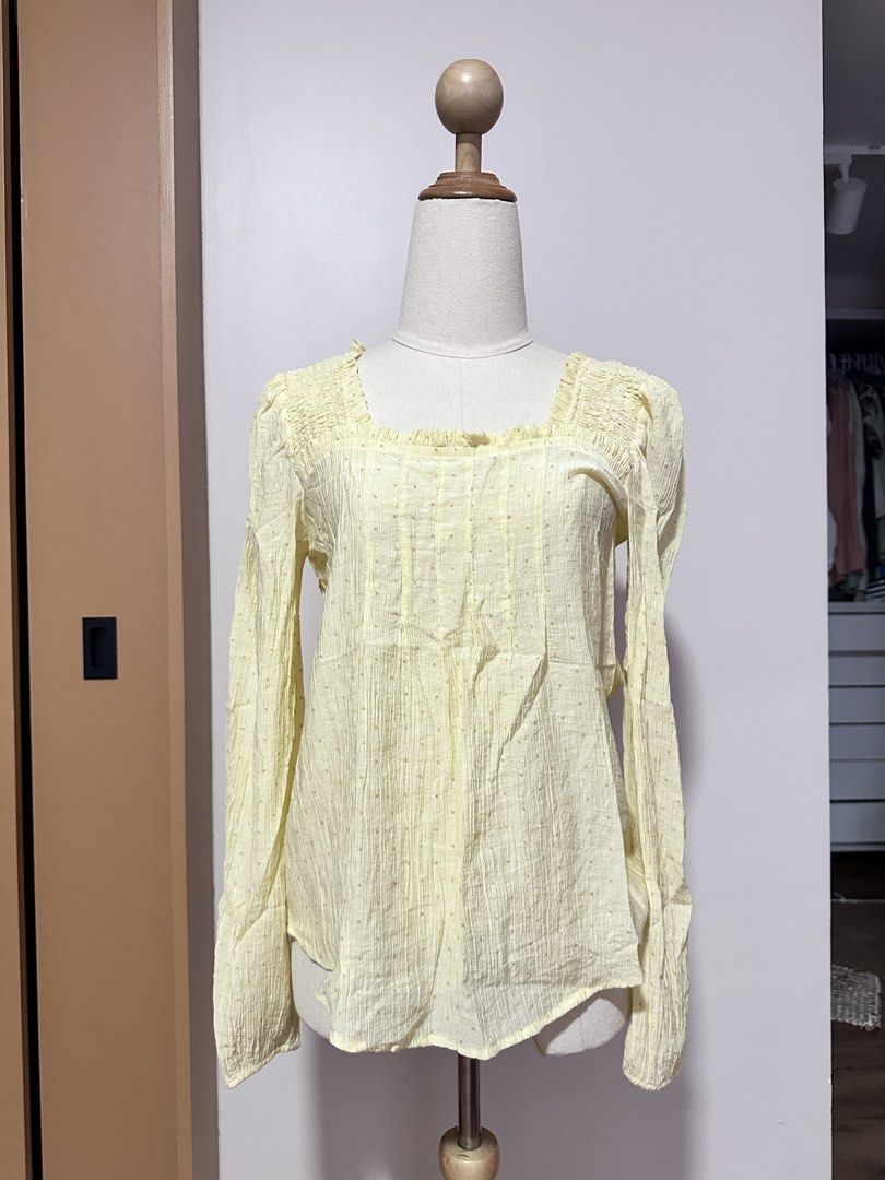 Yellow Square Neck Blouse (Category: Blouses) located in Tabuk. Submitted by classicseconds (Listing ID 1422767299, Image 1). Description: - Light yellow blouse - Square neckline - Long sleeves - Subtle dotted details - Slightly textured fabric - Relaxed fit - Lightweight material - Gathered detailing at neckline and front - Suitable for warm weather.