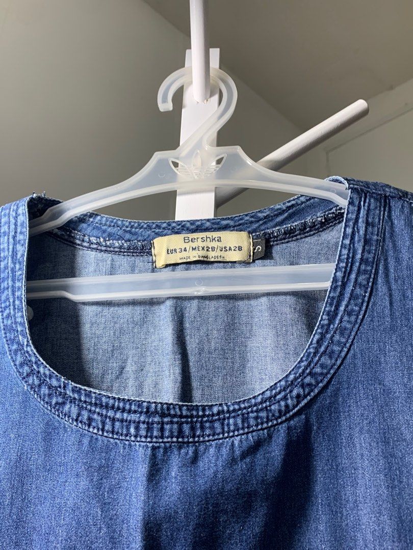 Bershka Denim Dress (Category: Dresses) located in Quezon City. Submitted by declutterwithm (Listing ID 1423019646, Image 2). Description: - Bershka denim dress - Round neckline - Short sleeves - Frayed hem - Relaxed fit - Medium blue wash - Casual style, ideal for everyday wear.