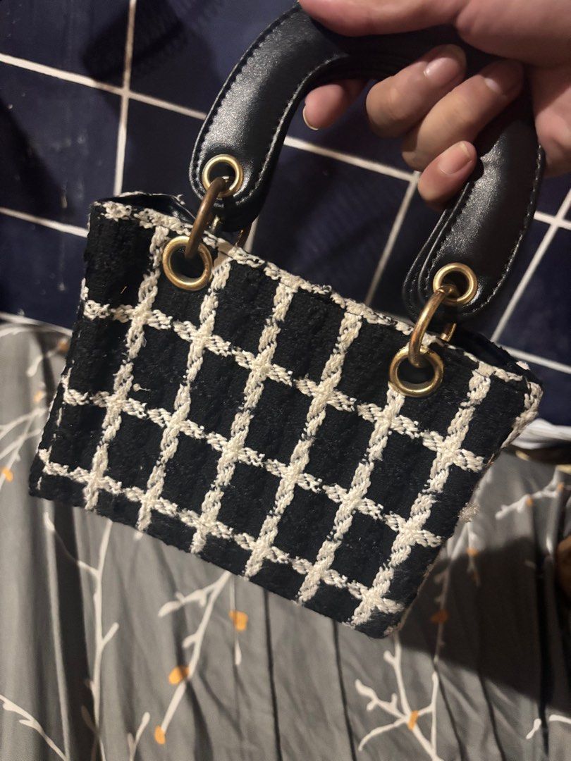 Black and White Tweed Handbag (Category: Luxury Bags & Wallets) located in Pateros City. Submitted by florocampo48421 (Listing ID 1423035294, Image 2). Description: - Stylish black and white tweed handbag - Structured design with a top handle - Elegant gold-colored hardware - Secure zippered closure - Compact size, ideal for carrying essentials - Black interior.