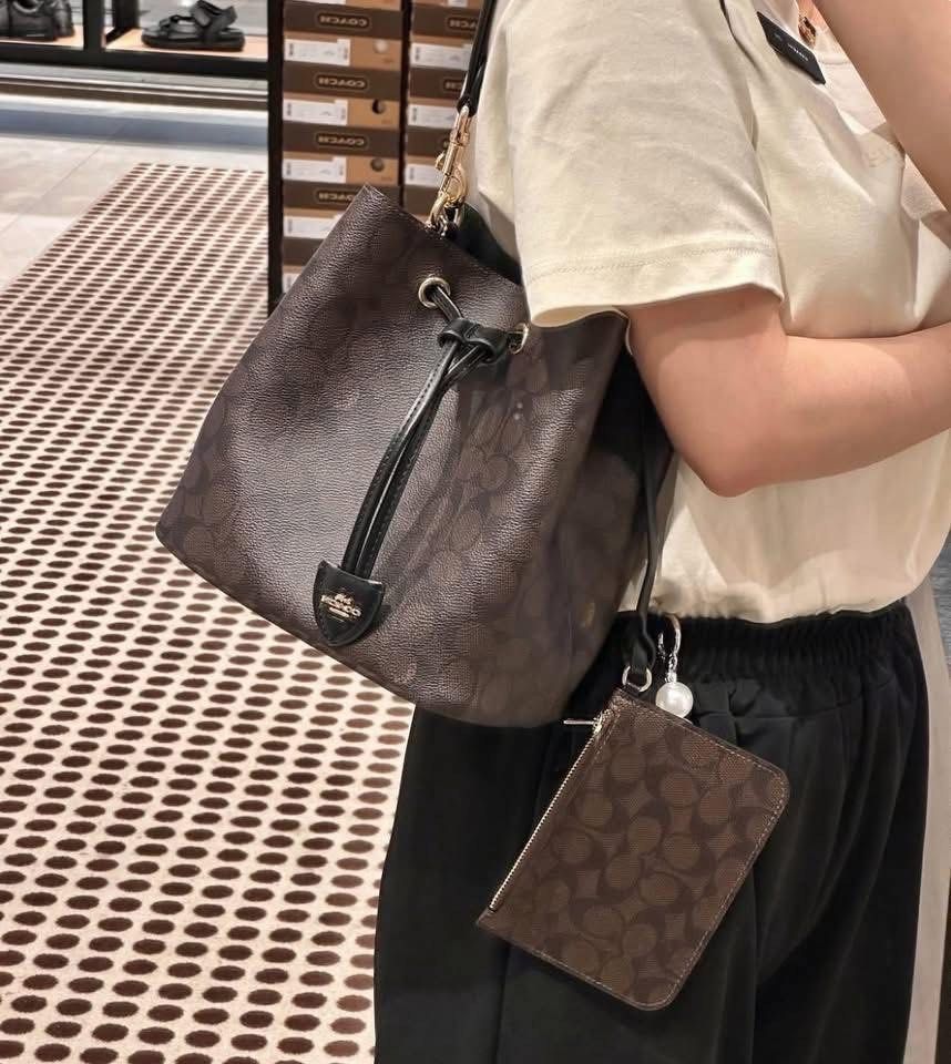 Coach Signature Bucket Bag (Category: Luxury Bags & Wallets) located in Caloocan City. Submitted by ericavi_g (Listing ID 1422906901, Image 2). Description: - Coach bucket bag - Signature brown pattern - Detachable pouch included - Drawstring closure - Gold-tone hardware - Shoulder strap - Versatile for everyday use orig brandnew.