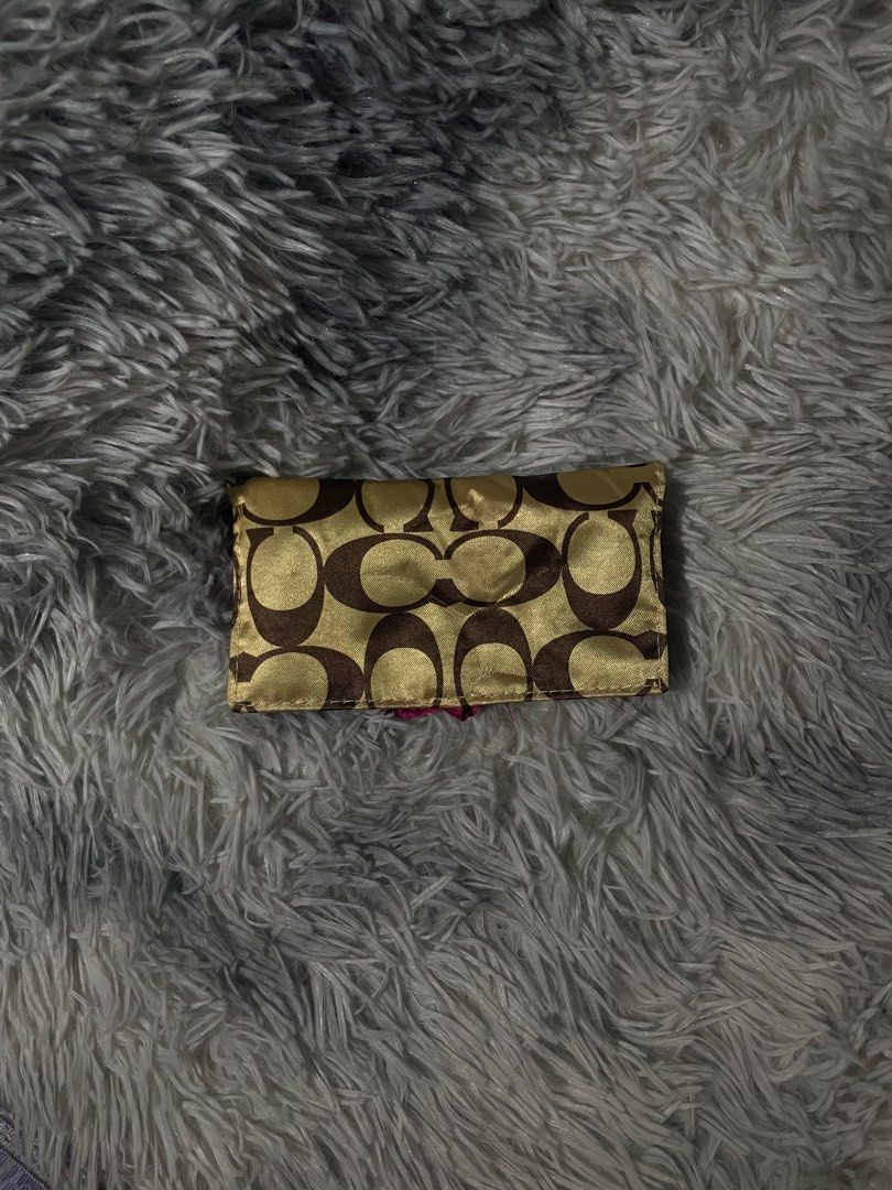 Coach Wallet (Category: Luxury Bags & Wallets) located in Trece Martires City. Submitted by zav_vinny (Listing ID 1423037864, Image 1). Description: - Coach wallet with signature logo pattern (brown and gold). - Vibrant pink interior. - Includes a zippered compartment. - Secure snap closure. - Comes with a strap. - Compact and stylish design. - still nego.