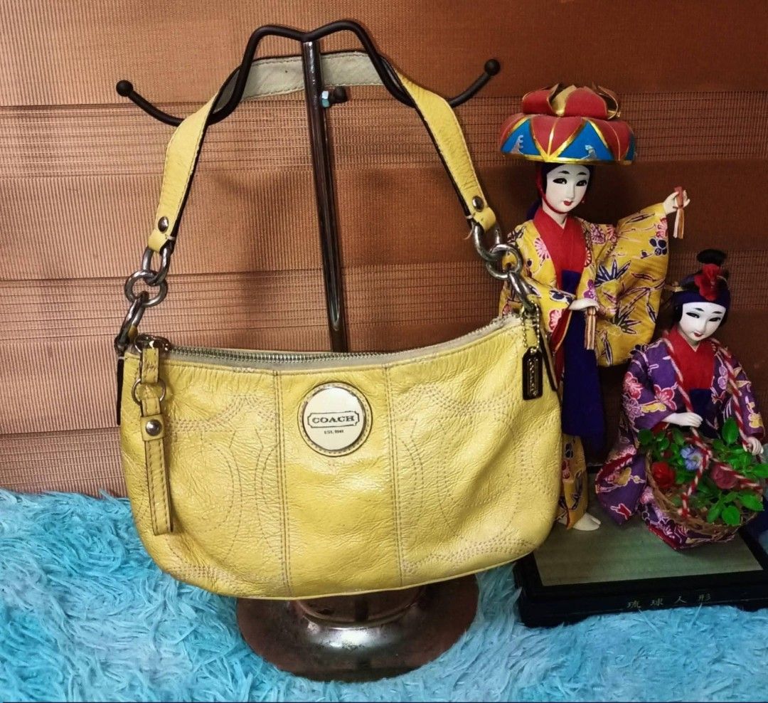 Coach Yellow Shoulder Bag (Category: Luxury Bags & Wallets) located in Baco. Submitted by happy.trixiadawn (Listing ID 1423010876, Image 1). Description: Coach shoulder bag features a yellow leather exterior with a zip closure. It has a single shoulder strap and a small Coach tag. The bag has a circular Coach logo on the front..
