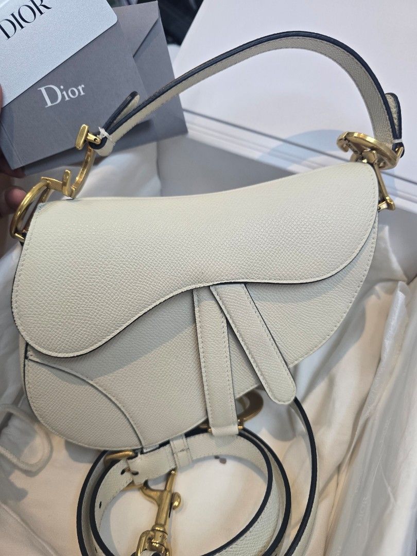 Dior Saddle Mini White Leather Bag (Category: Luxury Bags & Wallets) located in Taguig. Submitted by mluxeph (Listing ID 1422958903, Image 2). Description: Dior Saddle Mini White Leather Bag Material: Grained calfskin leather Stamp: 09 MA 0273 Year: 2023 Interior: One main compartment Measurements: 7”L X 2.1”W X 6”H Handle Drop: 4.1" Hardware: Gold tone Inclusions: Original box, original dust bag, removable strap and care card.