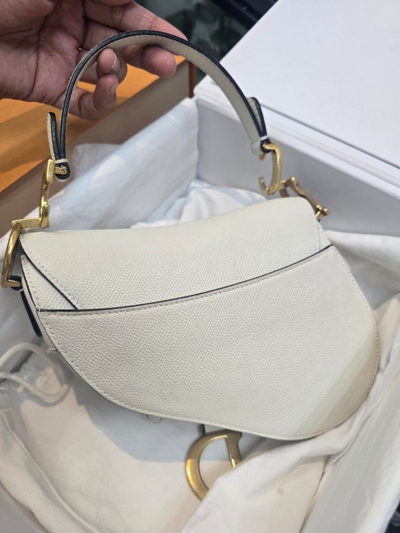 Dior Saddle Mini White Leather Bag (Category: Luxury Bags & Wallets) located in Taguig. Submitted by mluxeph (Listing ID 1422958903, Image 3). Description: Dior Saddle Mini White Leather Bag Material: Grained calfskin leather Stamp: 09 MA 0273 Year: 2023 Interior: One main compartment Measurements: 7”L X 2.1”W X 6”H Handle Drop: 4.1" Hardware: Gold tone Inclusions: Original box, original dust bag, removable strap and care card.