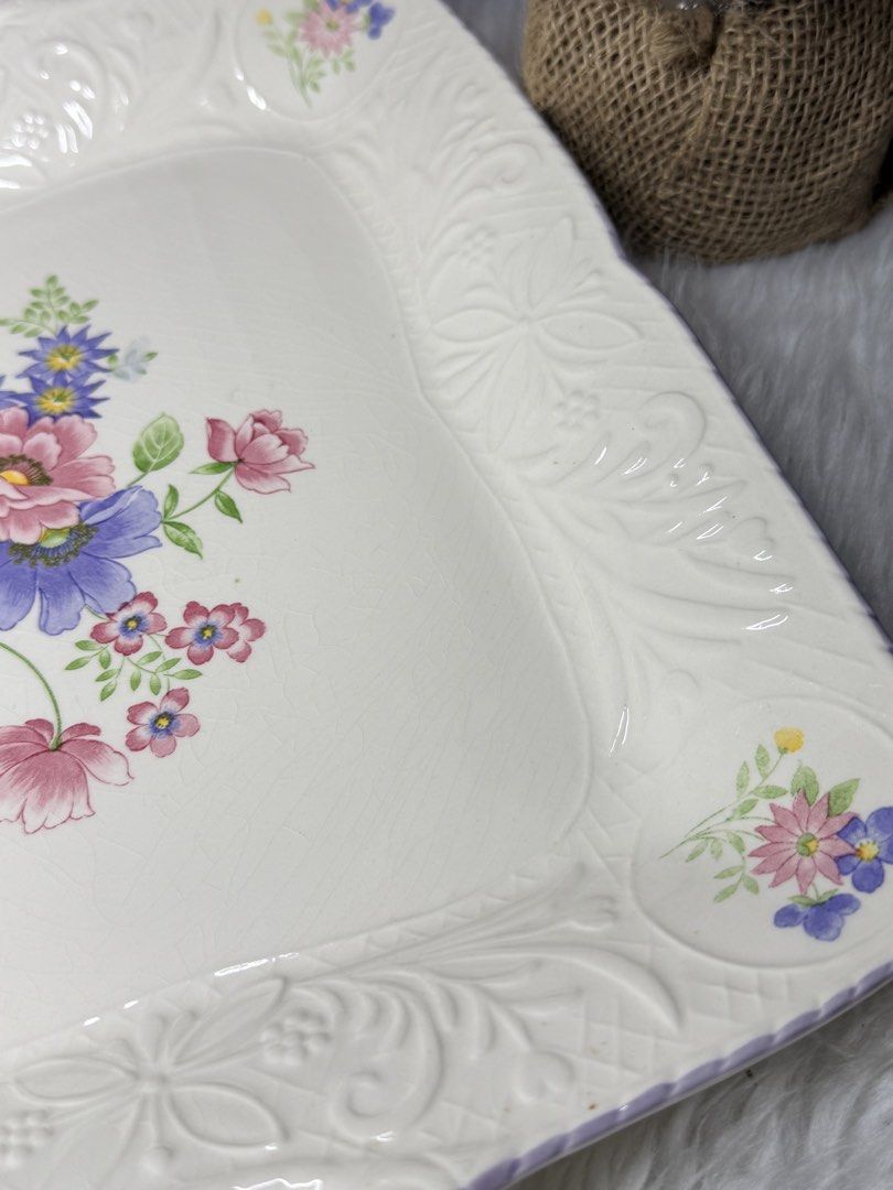Floral Design Serving Tray with Handles (Category: Other Kitchenware & Tableware) located in Manila. Submitted by prelovedbyramiah (Listing ID 1423036161, Image 3). Description: - Floral design serving tray - Square shape with handles - White base with purple trim - Embossed floral patterns - Approximately 12 inches long.