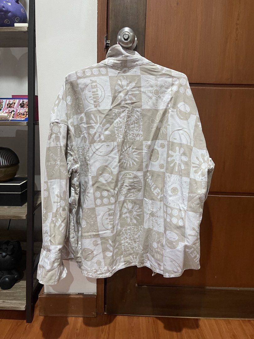 H&M Smiley oversized denim jacket (Category: Shirts) located in Cainta. Submitted by engelerrrr (Listing ID 1422966650, Image 2). Description: - H&M x Smiley collaboration shirt - Size: M - Color: Beige and white - Features: Button-down front, two chest pockets, long sleeves - Design: Unique pattern with smiley faces.