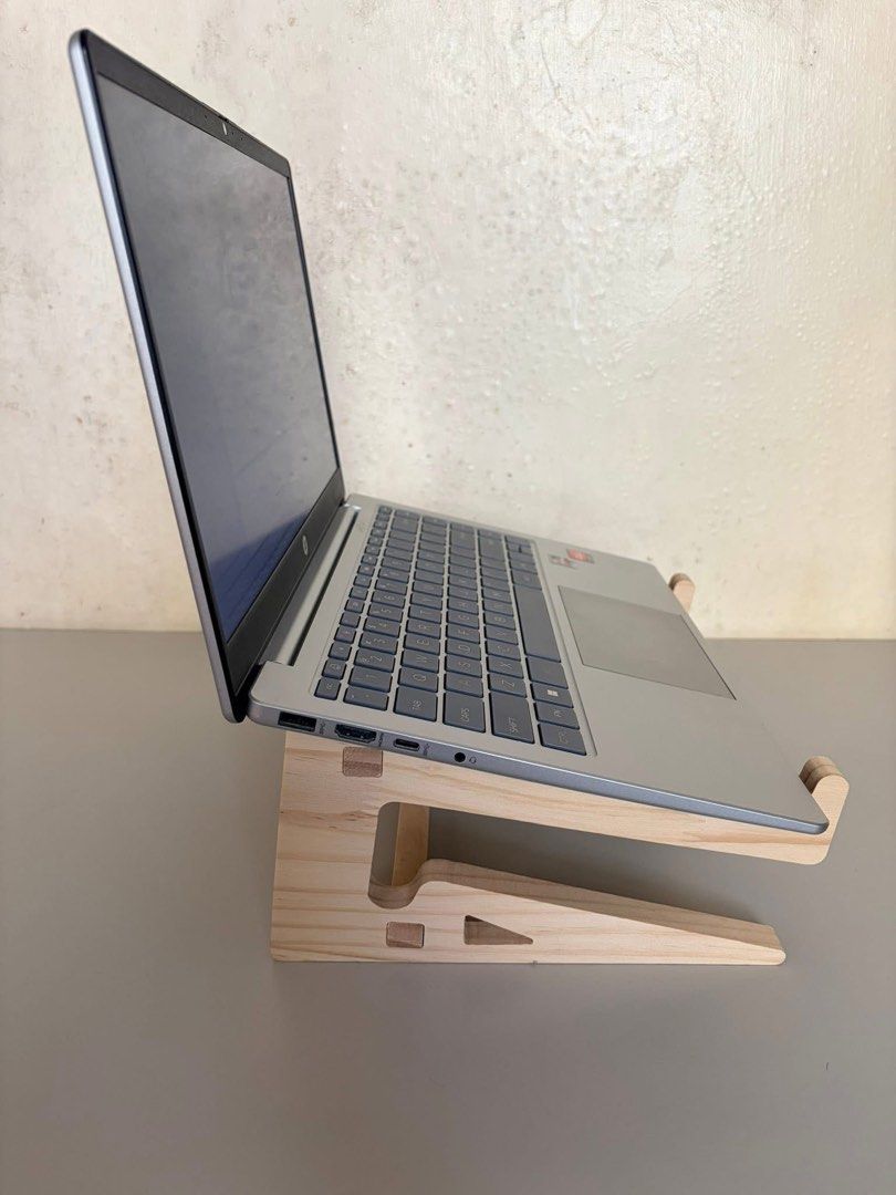 HP Laptop (Category: Laptops & Notebooks) located in Batangas. Submitted by seiferdg (Listing ID 1422920175, Image 2). Description: - Silver HP laptop - Windows 11 update in progress - Standard keyboard layout - AMD processor - Includes wooden laptop stand - Features HP logo.