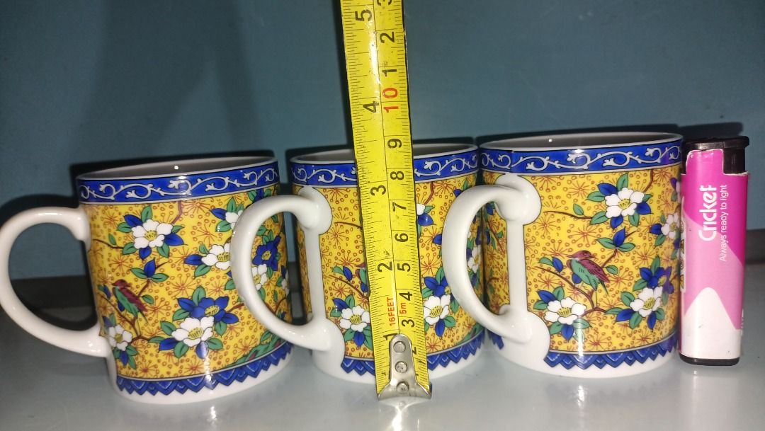 Kutani Maruishi Mug 150 each (Category: Coffee & Tea Tableware) located in Munoz. Submitted by larryc1212 (Listing ID 1423070362, Image 3). Description: Set of three vintage mugs featuring a vibrant yellow background with a floral and bird design. Each mug has a white handle and a blue rim. The mugs appear to be of a standard size, suitable for coffee or tea. The bottom of the mug has a green sticker. The mugs are approximately 3 inches in diamet