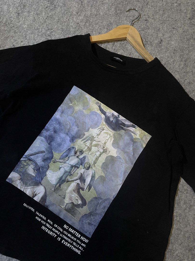 Othermix Graphic Print T-shirt (Category: Shirts) located in Don Carlos. Submitted by vianjn (Listing ID 1422940948, Image 2). Description: - Black Othermix T-shirt - Features an angel graphic print with a quote - Short sleeves and crew neck - Size: Medium - Material: Cotton - Brand tag included.