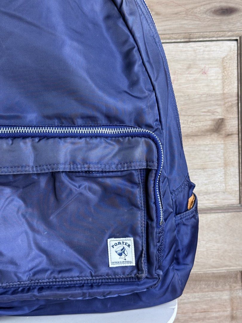 Porter International Navy Backpack (Category: Backpacks) located in San Pablo. Submitted by zzz.archvs (Listing ID 1423008670, Image 2). Description: - Navy blue Porter International backpack - Front zip pocket - Top handle - Adjustable shoulder straps - Orange interior - Zipper closure - Porter International logo on front - Unique zipper design - Made of nylon.