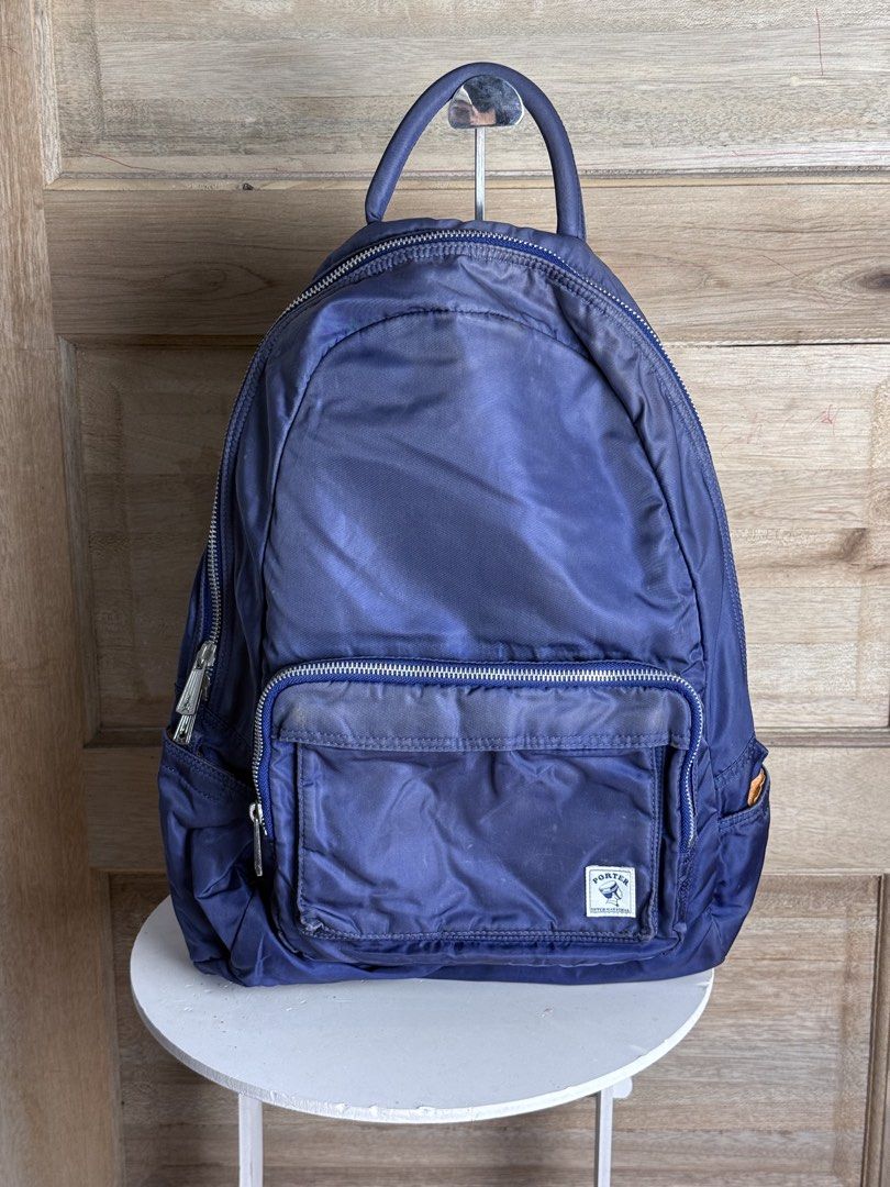 Porter International Navy Backpack (Category: Backpacks) located in San Pablo. Submitted by zzz.archvs (Listing ID 1423008670, Image 1). Description: - Navy blue Porter International backpack - Front zip pocket - Top handle - Adjustable shoulder straps - Orange interior - Zipper closure - Porter International logo on front - Unique zipper design - Made of nylon.