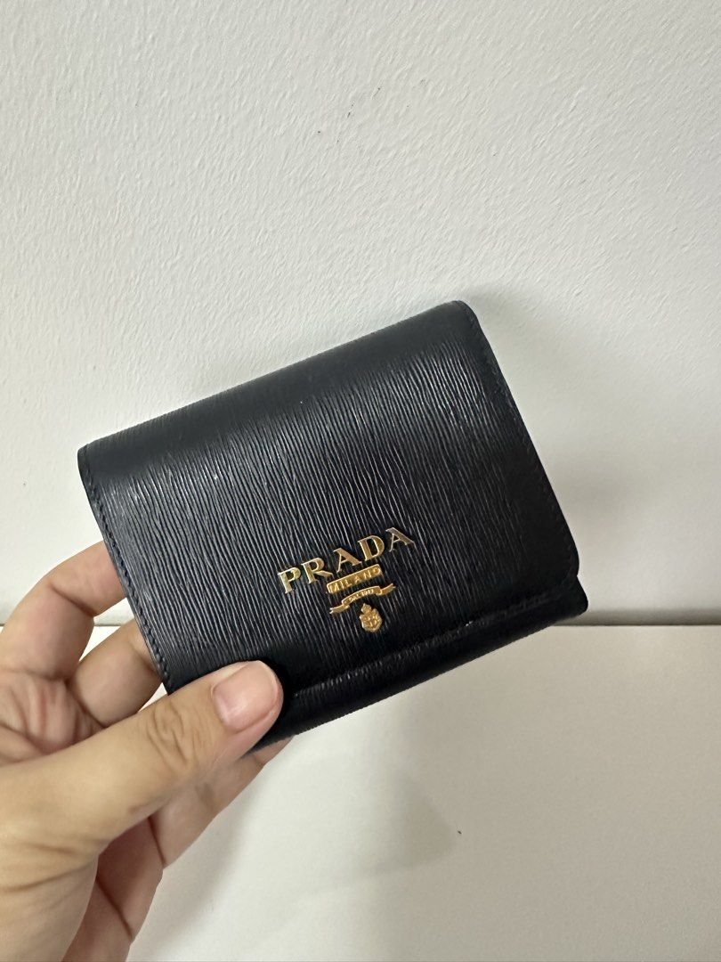 Prada Saffiano Leather Wallet (Category: Luxury Bags & Wallets) located in Quezon City. Submitted by general_cleanup (Listing ID 1423017983, Image 2). Description: - Authentic Prada wallet - Black Saffiano leather - Gold Prada logo - Includes: original box, dust bag, authenticity card, and shopping bag - Interior: multiple card slots and coin compartment - AURA Blockchain Consortium certified.