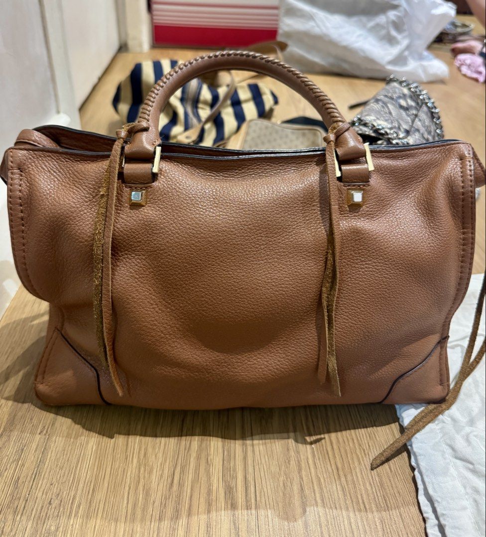 Rebecca Minkoff Brown Leather Handbag (Category: Luxury Bags & Wallets) located in Manila. Submitted by declutterkween14 (Listing ID 1422958112, Image 2). Description: - Brown leather handbag - Top handle and zip closure - Front zip pocket - Decorative tassels - Gold-toned hardware - Structured shape - Pebbled leather finish.