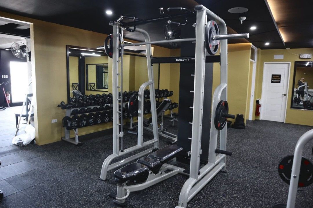 Smith Machine (Category: Cardio & Fitness Machines) located in Caloocan City. Submitted by protein888 (Listing ID 1422947697, Image 2). Description: Buildfit Smith Machine with adjustable bench. Features a pull-up bar and weight storage pegs. Includes a barbell. Suitable for various exercises. The machine is sturdy and designed for home or commercial gyms. The bench is adjustable for different angles. The frame is made of durable metal..