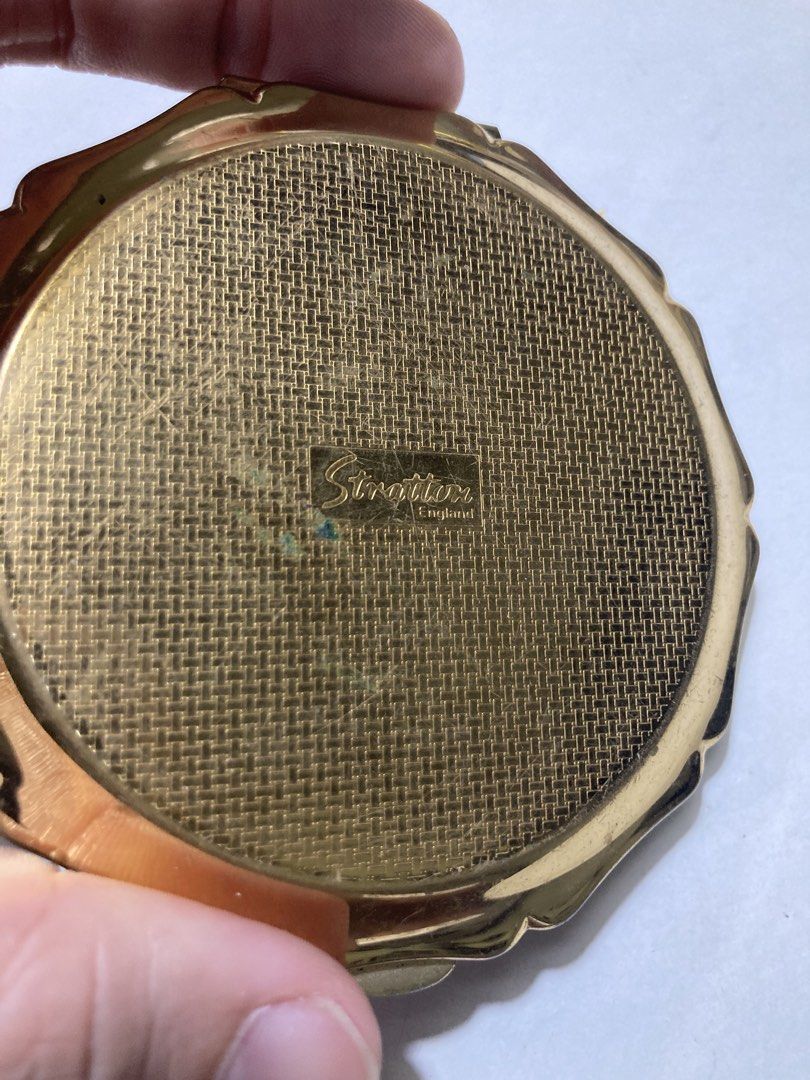 Stratton England Floral Powder Compact (Category: Makeup) located in Plaridel. Submitted by emilia.lily (Listing ID 1423045882, Image 3). Description: - Vintage Stratton England powder compact - White lid with floral design - Gold-tone metal frame - Includes mirror, powder screen, and powder puff - Textured back - Octagonal shape with scalloped edge - Marked 'Stratton England'.