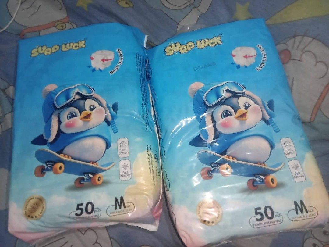 Surp Luck Baby Diapers Medium 50pcs (Category: Diapers & Baby Wipes) located in Quezon City. Submitted by moonchayo (Listing ID 1422997294, Image 2). Description: - Surp Luck baby diapers - Size: Medium - 50 pieces per pack - Adorable penguin design - Soft cotton material - Fast absorbing - Available in blue and yellow packaging.