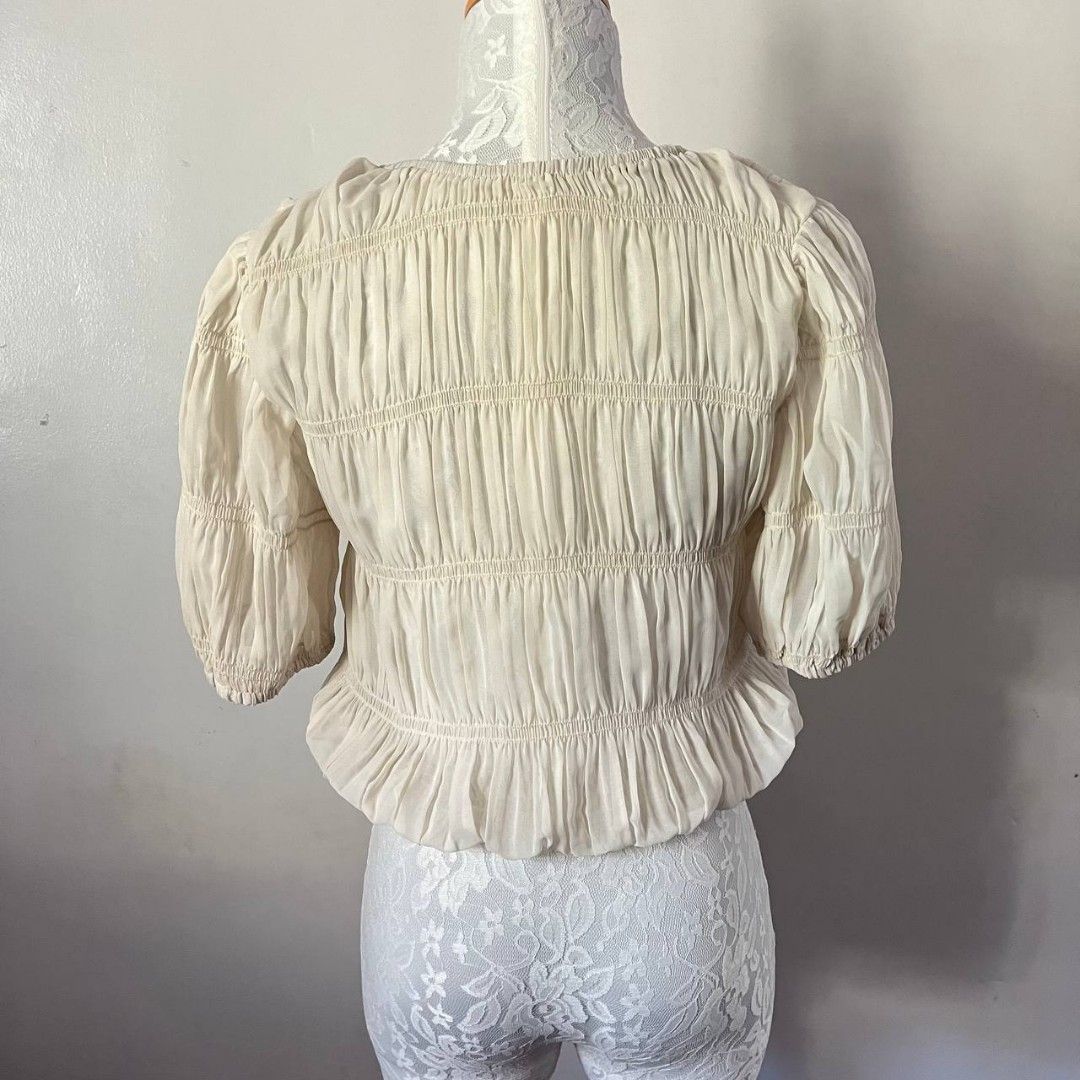 Vintage Cream Ruched Top (Category: Blouses) located in San Mateo. Submitted by prelouve (Listing ID 1423038796, Image 3). Description: - Cream-colored crop top - Features a ruched design - Short, puffed sleeve.