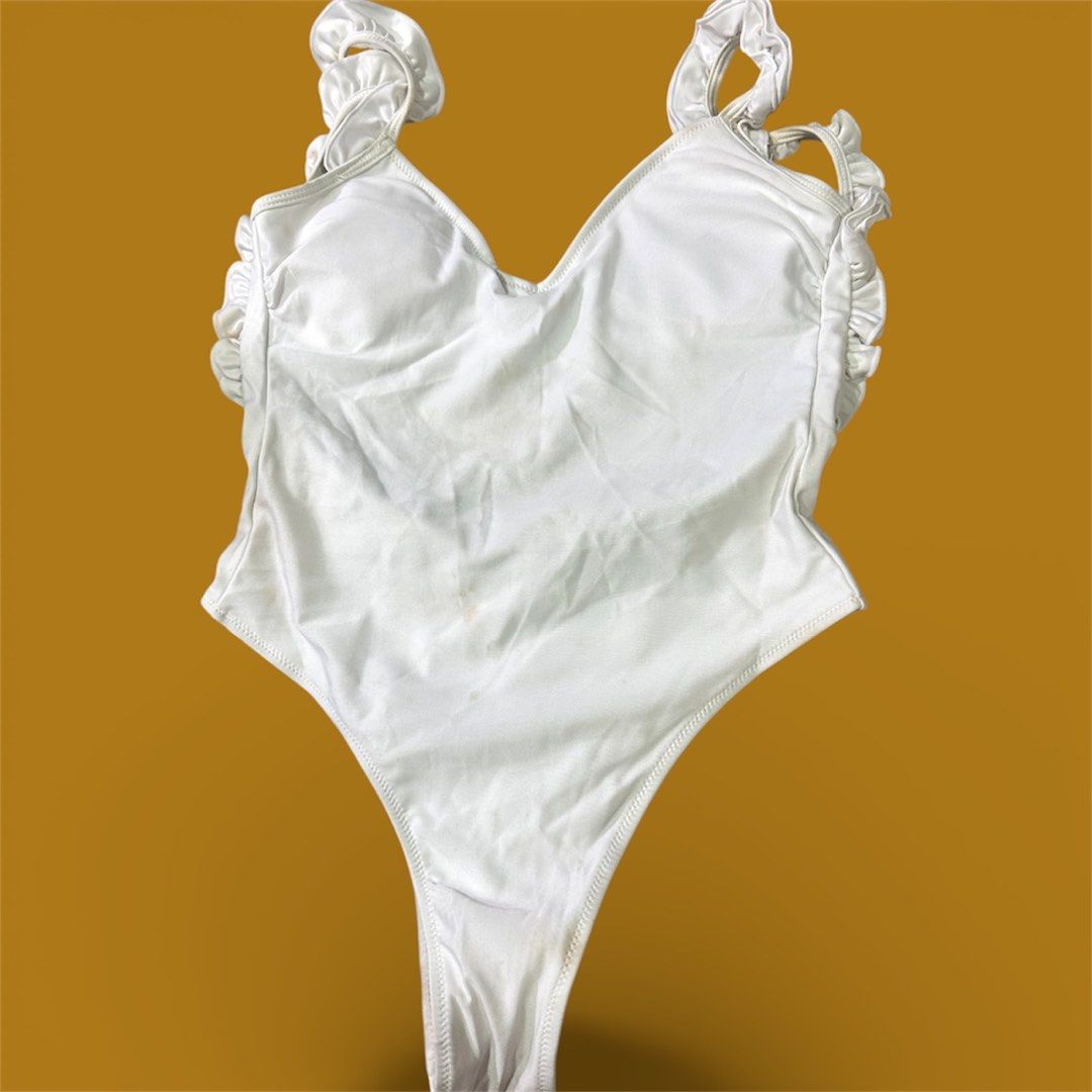 White Ruffle Low back One-Piece Swimsuit (Category: Bikinis & Swimsuits) located in Manila. Submitted by AngelResty (Listing ID 1423016913, Image 1). Description: - White one-piece swimsuit - Ruffle detailing on straps and neckline - Scoop neckline - High-cut leg design - Low scoop back with ruffle trim - Made of smooth, possibly shiny fabric.
