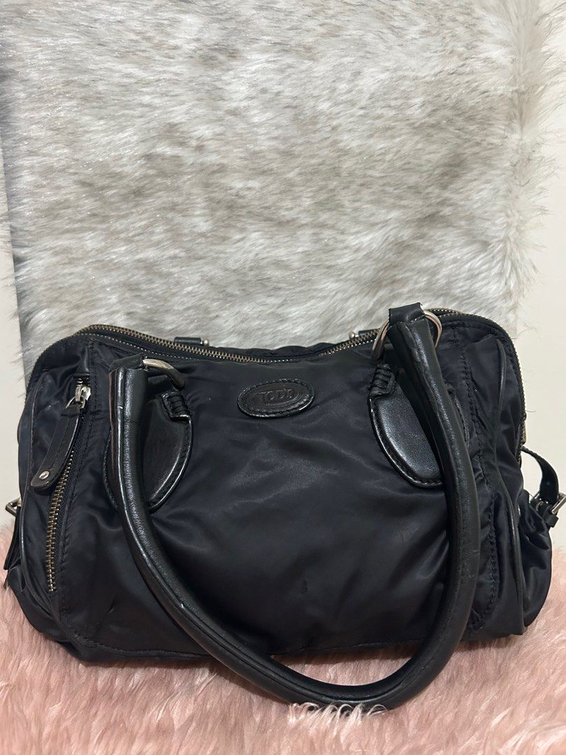 Authentic Tods bag (Category: Luxury Bags & Wallets) located in Quezon City. Submitted by heycathiee (Listing ID 1423150652, Image 1). Description: Tods Bag ~ authentic ~ vintage looking ; nylon material ~ can be worn as kili, sling , handbag ~ with provided sling only ~ 2 compartments (yung back part may pinhole, tho d nmn tumagos s lining ng bag) ~ may light dirt yung nylon nya, plus may light rubs yung logo nya (full black p naman, pero yung e