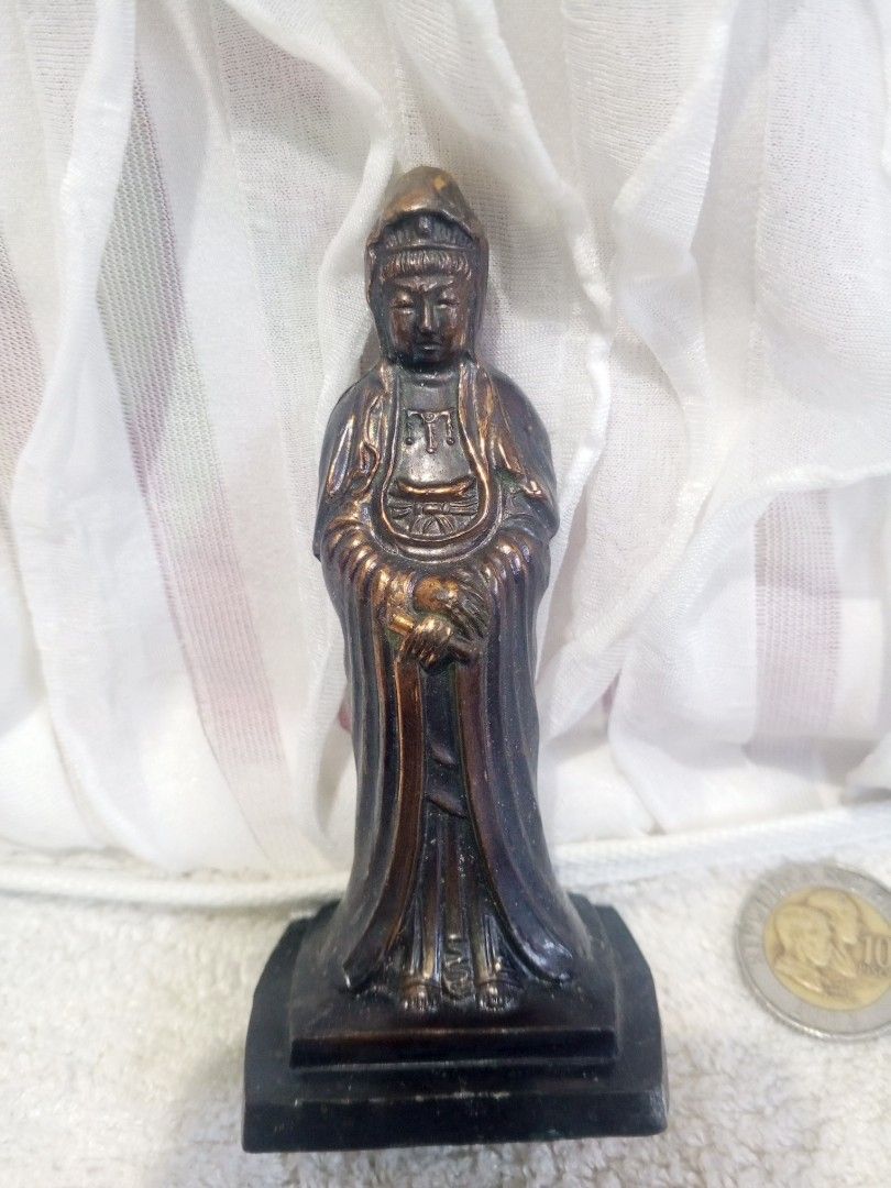 Bronze Guan Yin Statue (Category: Religious Items) located in Makati City. Submitted by nherlhez_24 (Listing ID 1423171779, Image 1). Description: Bronze statue depicts Guan Yin, a revered figure in Buddhism. The statue features intricate details and stands on a rectangular base. The back of the statue has Chinese characters. The statue is a dark bronze color metal..