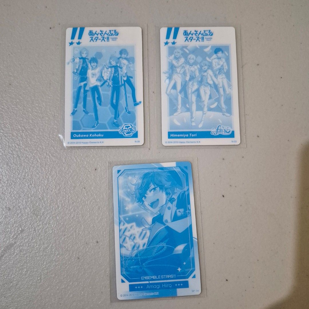 Ensemble Stars! Trading Cards (Category: Raw Singles) located in Cebu City. Submitted by snuggleplushph (Listing ID 1423186500, Image 2). Description: - Ensemble Stars! trading card set. - Featuring characters like Oukawa Kohaku and Amagi Hiro. - Cards are in protective sleeves. - Includes cards with a blue-tinted design. - Backs of cards show the Ensemble Stars! logo and character names..