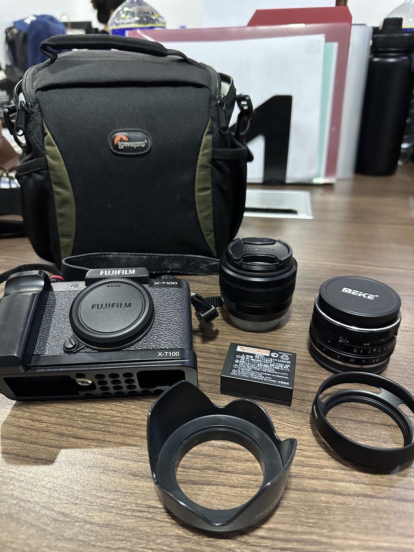 Fujifilm X-T100 Camera with Accessories (Category: Cameras) located in Mandaluyong City. Submitted by clairebear_ (Listing ID 1423092894, Image 2). Description: POSTING FOR A FRIEND: - Fujifilm X-T100 camera (black body) - Includes multiple lenses (Meike lens included) - Comes with camera bag (LowePro) - Extra battery included - Lens hood included - Camera strap included - Screen displays image - No charger ISSUE: Inverted EVF Can meet up at Doub