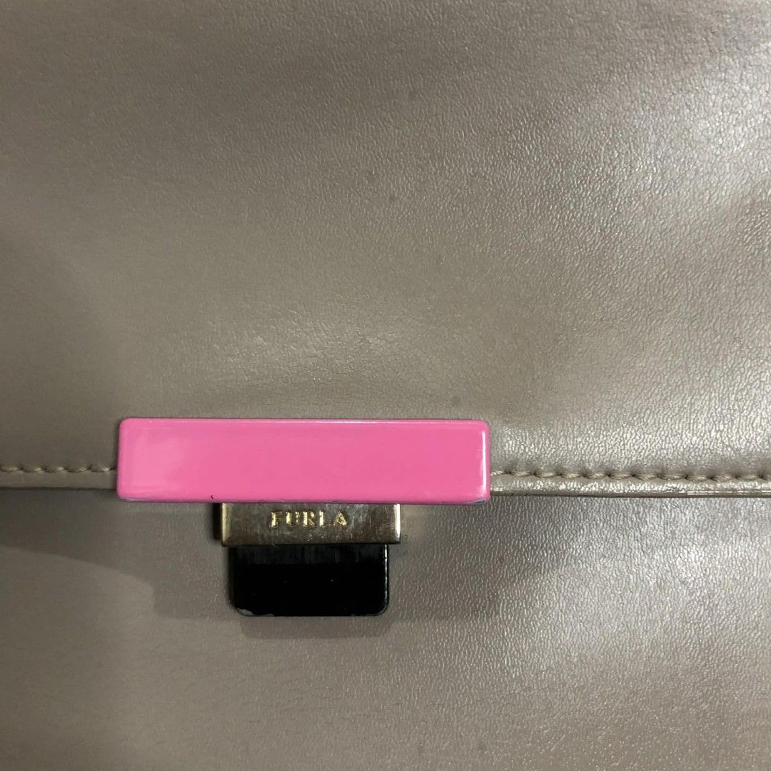 Furla Metropolis Crossbody Bag (Category: Luxury Bags & Wallets) located in Bayombong. Submitted by rnstrifty (Listing ID 1423254565, Image 3). Description: - Furla Metropolis crossbody bag - Grey leather exterior - Pink accent on clasp - Gold-tone handle - Detachable shoulder strap - Rectangular shape with flap closure - Furla logo visible.