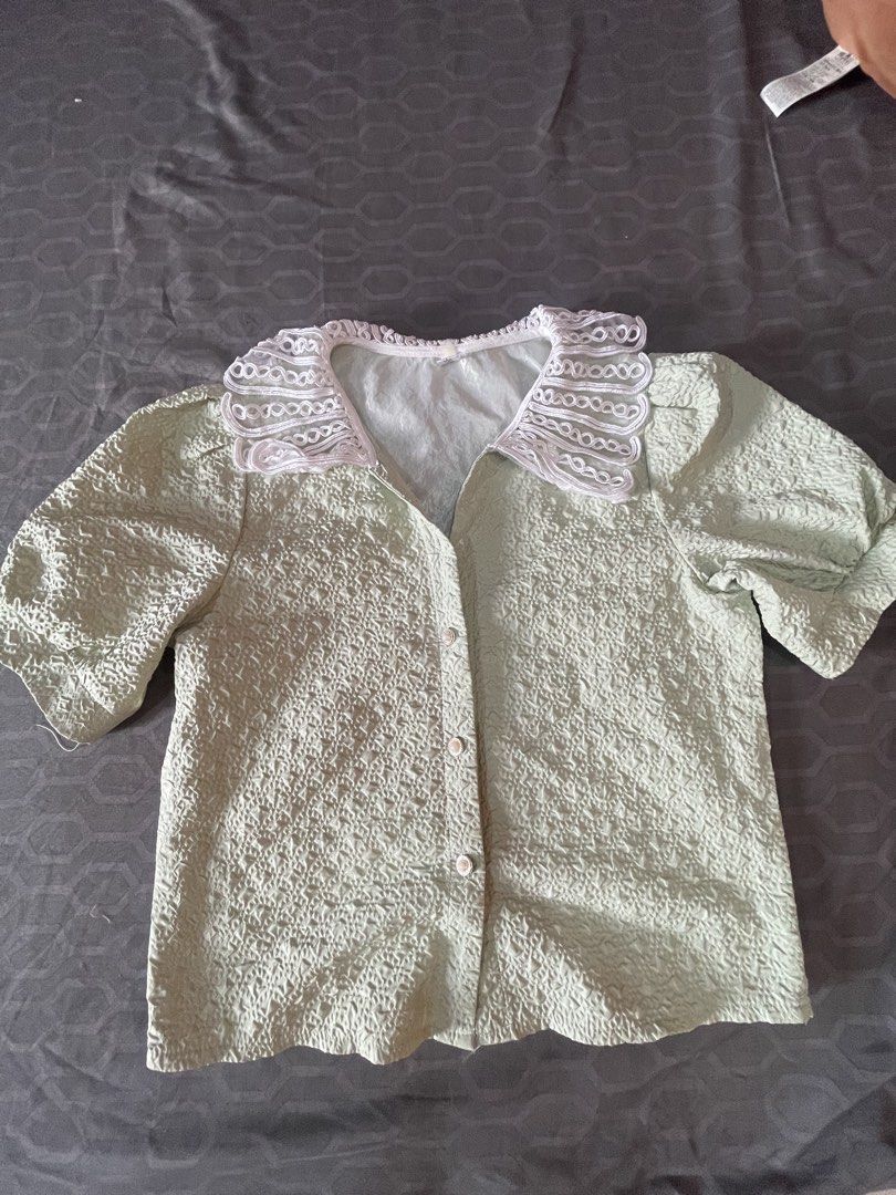 Green Textured Blouse with Lace Collar (Category: Blouses) located in Manila. Submitted by mc.thrifty (Listing ID 1423114395, Image 1). Description: - Soft green blouse - Textured fabric - Delicate lace collar - Short sleeves - Button-down front - Dress up or down - Adds elegance to any outfit.