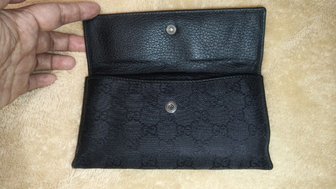 Gucci Black Wallet (Category: Luxury Bags & Wallets) located in Tanza. Submitted by declutterolshoppe (Listing ID 1423168824, Image 3). Description: - Authentic Gucci wallet - Black color - Snap closure - Multiple card slots and compartments - Textured leather exterior - Fabric lining with Gucci logo - Interior snap closure - Visible serial number.