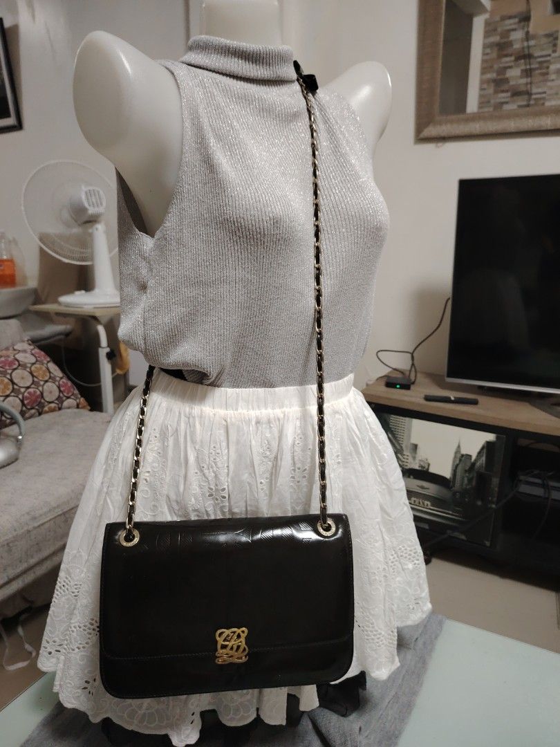 Louis Quatorze Black Chain Shoulder Bag (Category: Shoulder Bags) located in Muntinlupa City. Submitted by jovyrivera0824 (Listing ID 1423182337, Image 2). Description: - Elegant black shoulder bag - Features a gold-toned chain and leather strap - Decorative clasp and embossed pattern - Stylish bow detail on the strap - Classic design, perfect for any occasion -adjustable chain sling, can be shoulder or crossbody bag -multiple compartment.