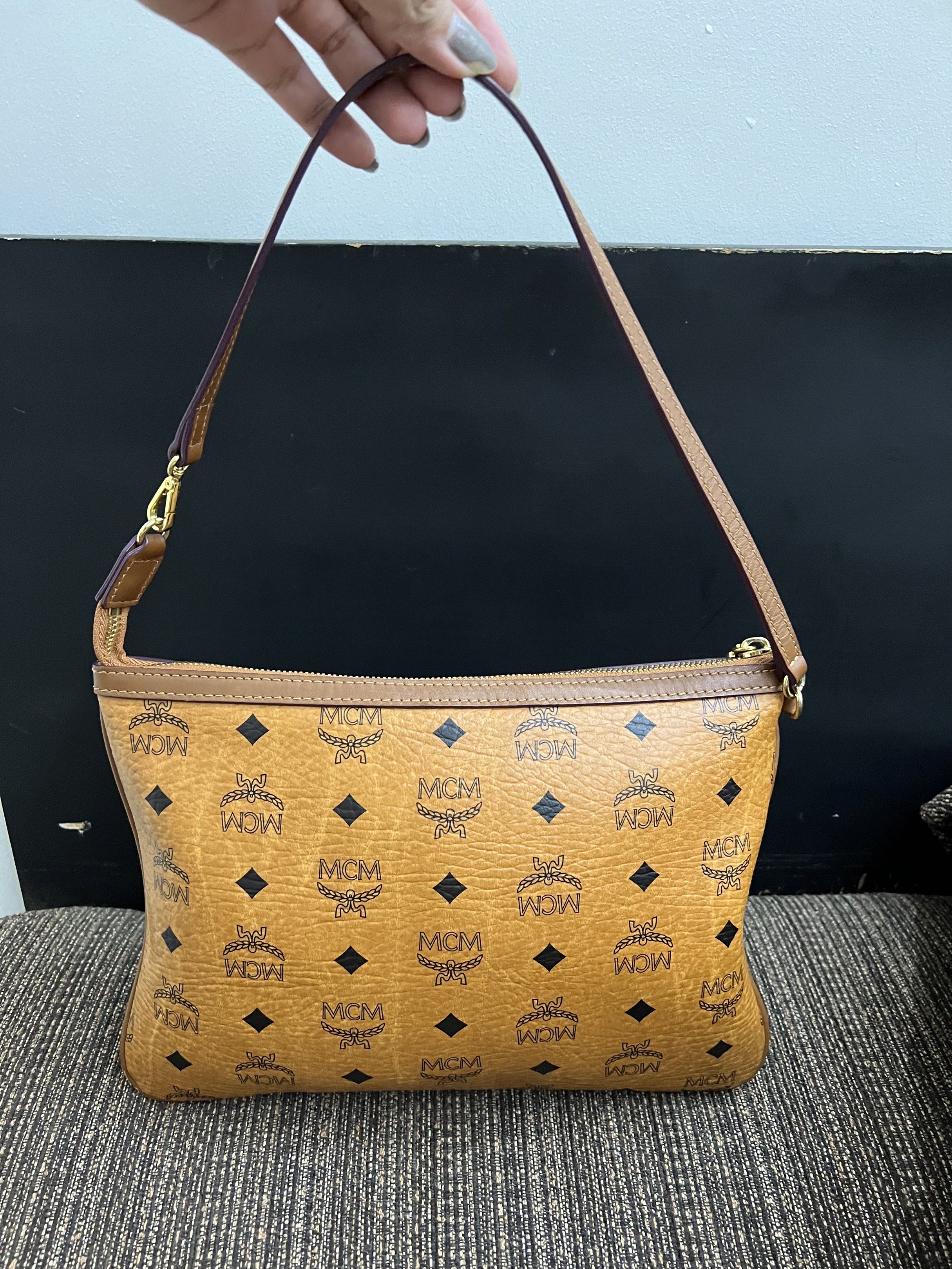 MCM Clutch Bag authentic preloved (Category: Luxury Bags & Wallets) located in San Pablo. Submitted by iamtrina (Listing ID 1423101318, Image 2). Description: - Authentic MCM clutch bag - Signature logo print - Brown exterior with matching strap - Gold-tone hardware - Light brown fabric lining - Made in Korea.
