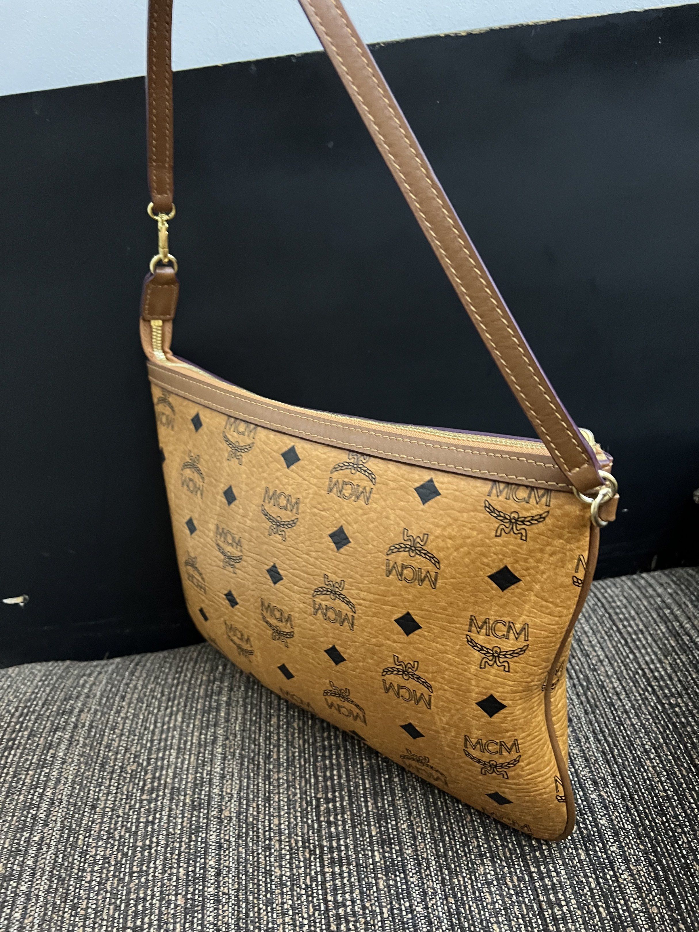 MCM Clutch Bag authentic preloved (Category: Luxury Bags & Wallets) located in San Pablo. Submitted by iamtrina (Listing ID 1423101318, Image 3). Description: - Authentic MCM clutch bag - Signature logo print - Brown exterior with matching strap - Gold-tone hardware - Light brown fabric lining - Made in Korea.